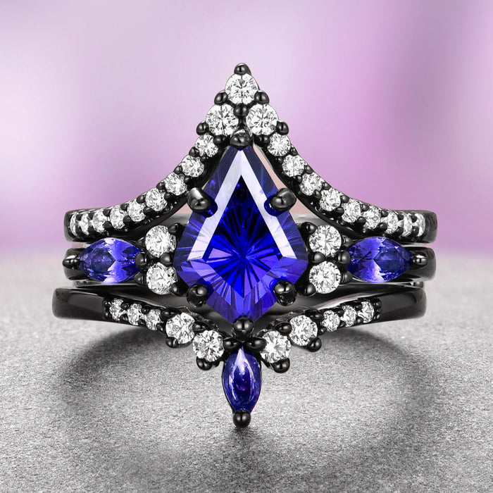 Skye Kite® Cornflower Sapphire Ring Set- Black Ruthenium displays a striking kite-cut cornflower blue sapphire centerpiece accented by marquise and round white gemstones on a black ruthenium over sterling silver band, crafted by Aquamarise and featured in September Birthstone Jewelry, Fantasy-Inspired Engagement Rings, and Lovers of the Dark™ collections.
