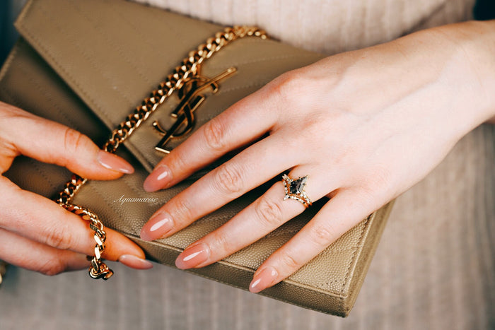 Skye Kite® Galaxy Herkimer Diamond & Meteorite Couples Ring Set by Aquamarise, featuring a distinctive Herkimer diamond and black meteorite band on a delicate hand holding a gold chain purse.