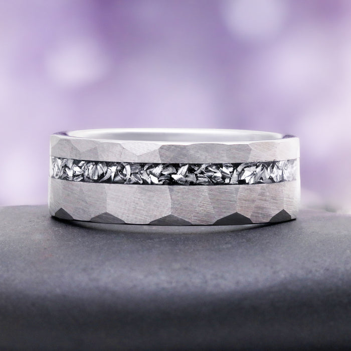 Hammered silver tungsten band on slate, showing the light-catching crushed meteorite channel