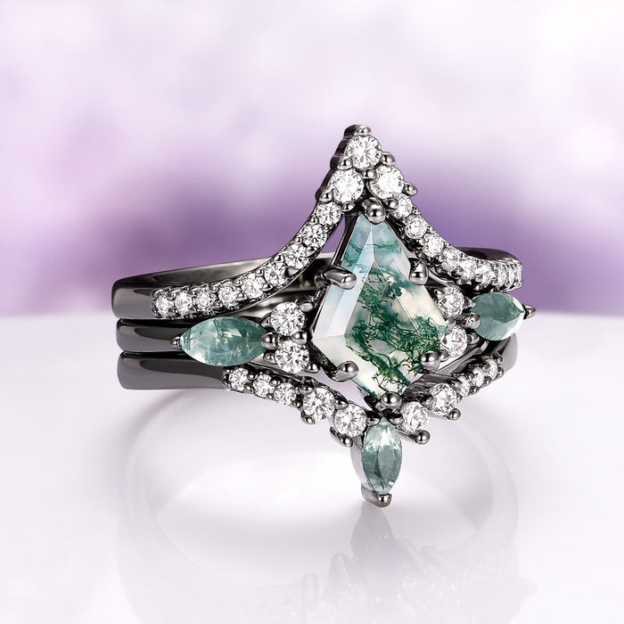 Skye Kite® Green Moss Agate Engagement Ring Set in Black Ruthenium (3-piece) by Aquamarise featuring a kite-cut moss agate center with green inclusions, accented by pear-shaped stones and a black ruthenium band with sparkling crystals.