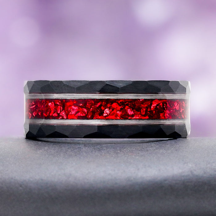 8mm Red Garnet men's wedding band in two tone tungsten carbide resting on a dark stone, showing the crushed garnet inlay and silver rails