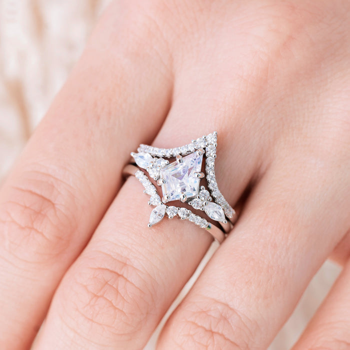 Silver engagement ring set with kite cut diamond center stone and accents on hand over a light background