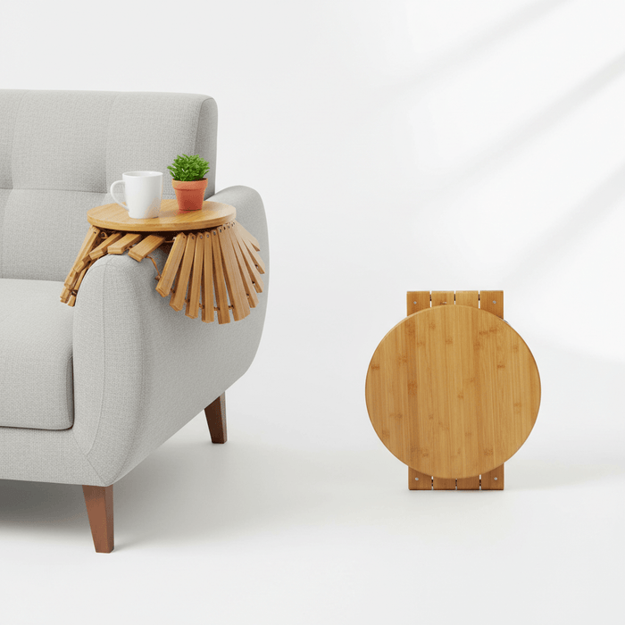 Sofa armrest tray on a grey couch with coffee cup and plant, showcasing a bamboo round clip-on side table for convenient organization.