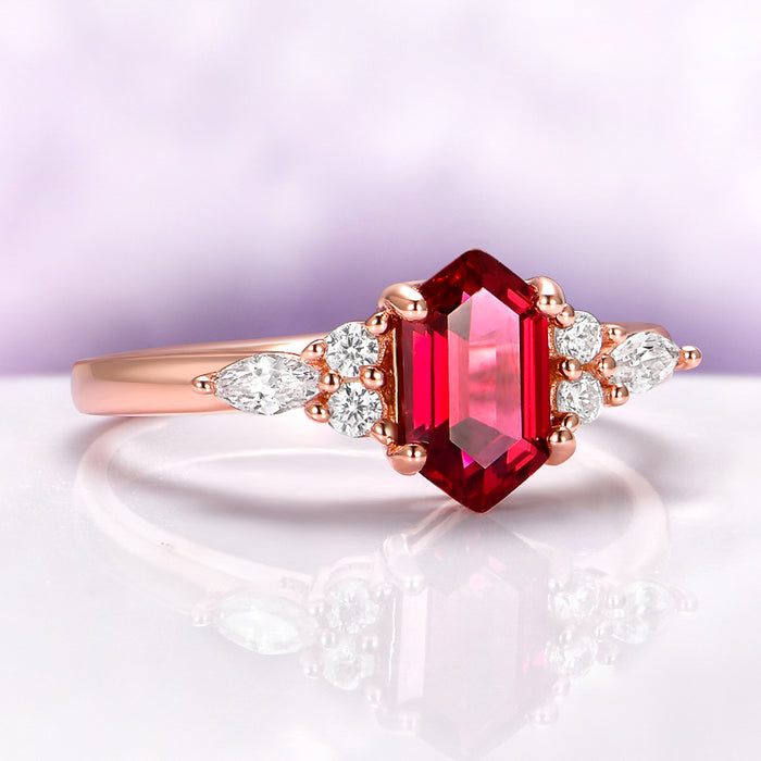 Sonnet Hexagon Ruby Engagement Ring in 14K Rose Gold Vermeil by Aquamarise, featuring a hexagon ruby center stone with pear and round accent diamonds on a polished rose gold band.