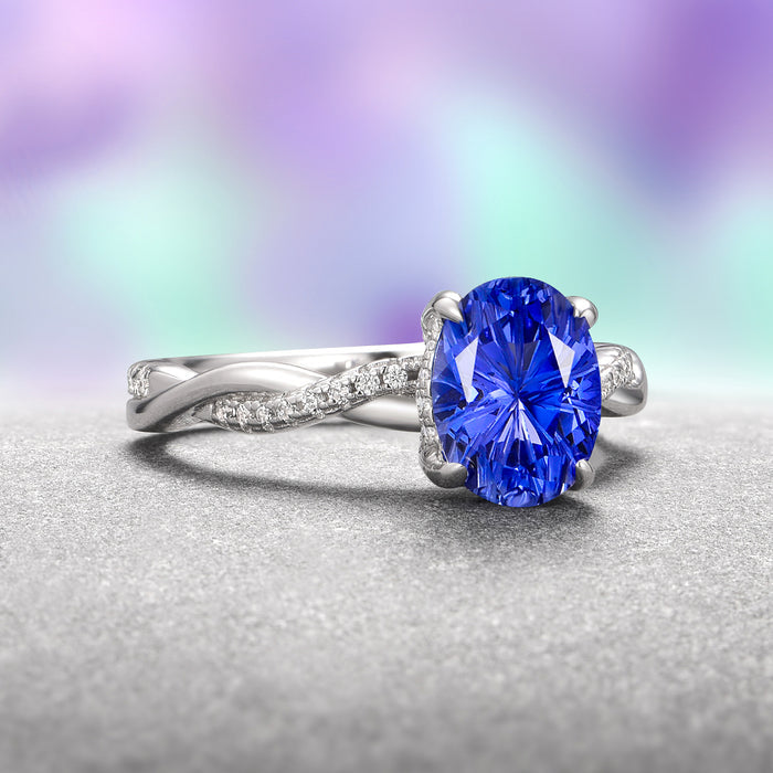 Sophia Fantasy Cut Sapphire Engagement Ring in 14K White Gold features an oval lab-grown blue sapphire with a fireworks cut set on a twisted white gold band accented by sparkling diamonds, an Aquamarise Gold design.