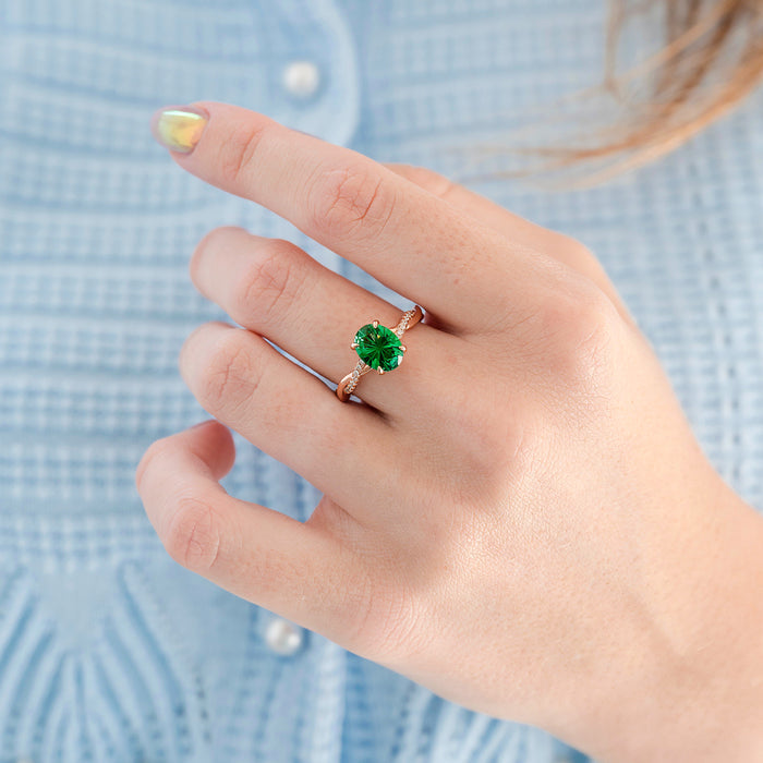 Sophia Fireworks Cut Emerald Engagement Ring in 14K Solid Rose Gold by Aquamarise Gold features a vibrant green fireworks-cut emerald set on a twisted rose gold band with delicate diamond accents, part of Solid Gold Engagement Rings and May Birthstone Jewelry collections.