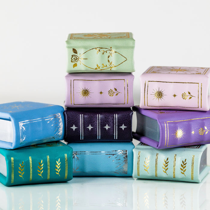 Summer Court Handmade Leather Book Ring Box- Ocean Tide Teal Edition (Small) by Aquamarise, stacked colorful handmade leather ring boxes with gold embossed designs, fantasy-inspired keepsakes.