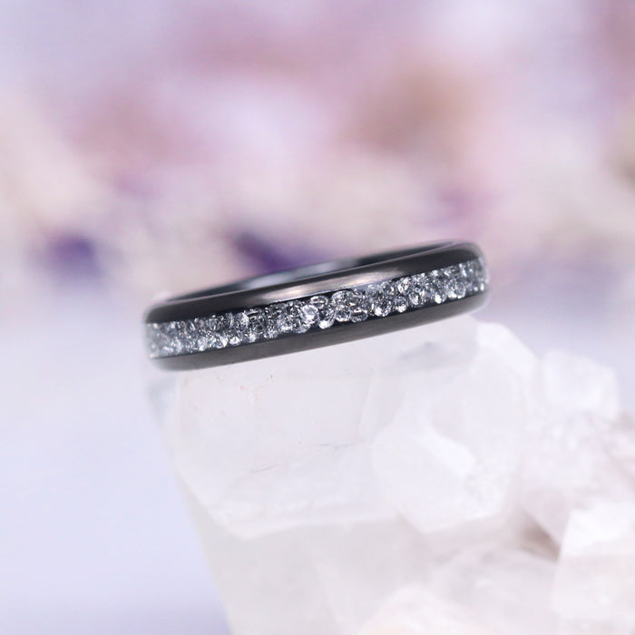 Starlux Simulated Crushed Diamond Couples Ring Set featuring a sleek black tungsten carbide band inlaid with shimmering silver stones, crafted by Aquamarise for Matching Couples' Rings and April Birthstone Jewelry collections.
