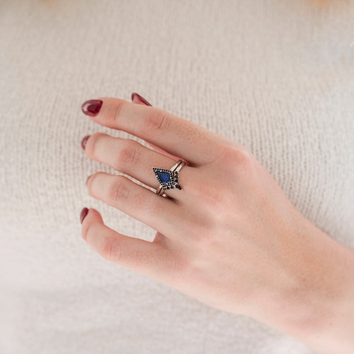 Starry Night & Black Onyx Engagement Ring Set in 14K White Gold on hand with deep red nail polish, featuring a kite-shaped blue stone surrounded by black onyx accents by Aquamarise Gold