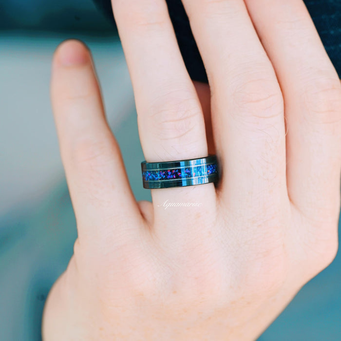 Starry Night & Blue Fire Opal Wedding Band- 8MM Black Tungsten ring with a vibrant crushed blue fire opal inlay and polished black tungsten edges, styled on a hand, crafted by Aquamarise from Men's Wedding Bands and October Birthstone collections.