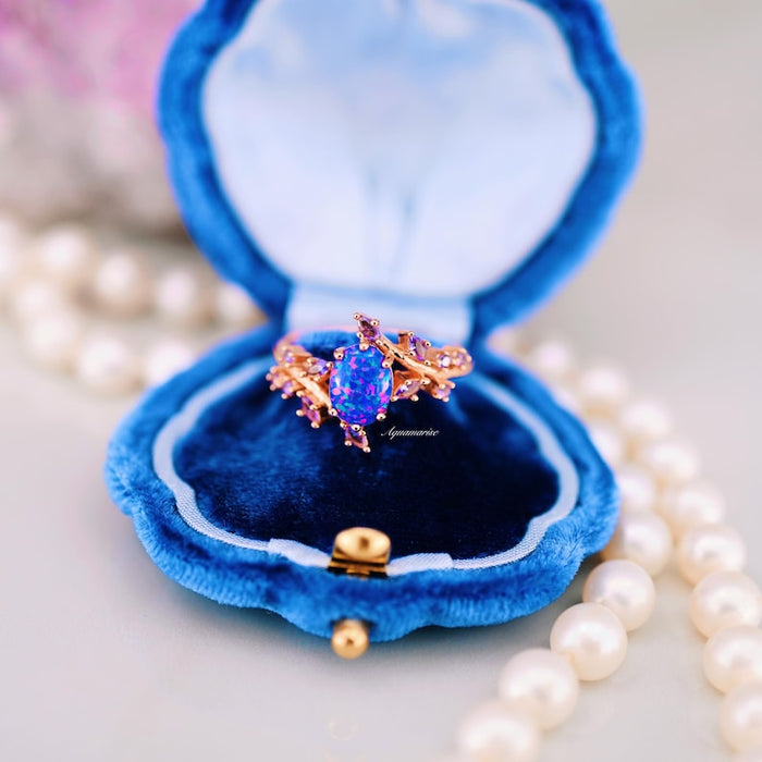 Starry Night Van Gogh Fire Opal & Rose Gold Leaf Couples Ring Set featuring a vivid blue and purple fire opal centerpiece with rose gold leaf-inspired band, displayed in a plush blue velvet box by Aquamarise.