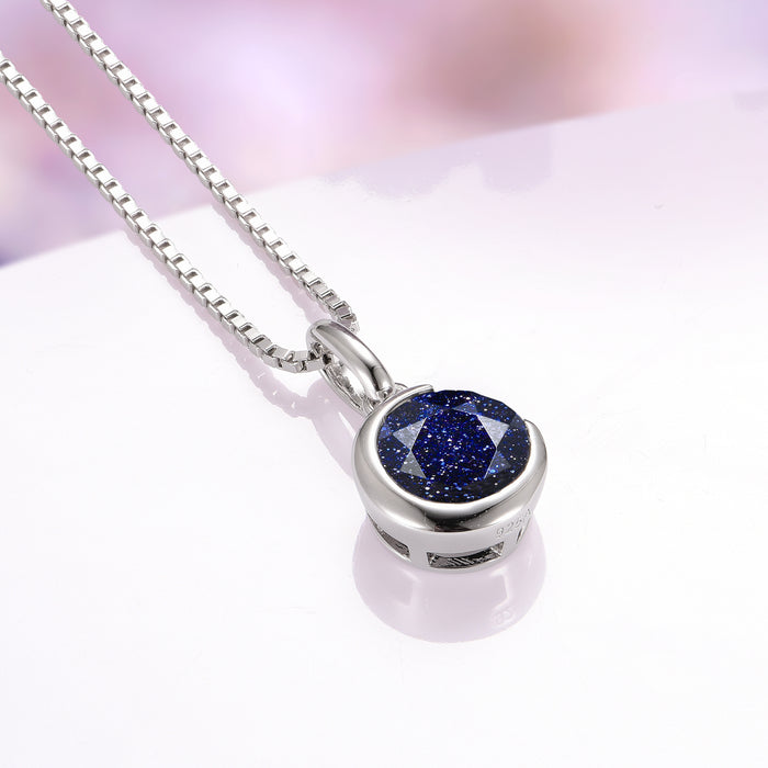 Starry Night Crescent Moon Necklace in Sterling Silver by Aquamarise, showcasing a sparkling round blue sandstone gemstone with deep midnight tones and shimmering flecks, set in polished 925 sterling silver, featured in collections including Necklaces and Birthstone Jewelry.