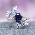 Starry Night & Sapphire Leaf Ring Set- 14K White Gold featuring a deep blue sapphire center stone surrounded by delicate leaf motifs with small blue and white gemstones, crafted by Aquamarise Gold from nature-inspired and starry night collections.