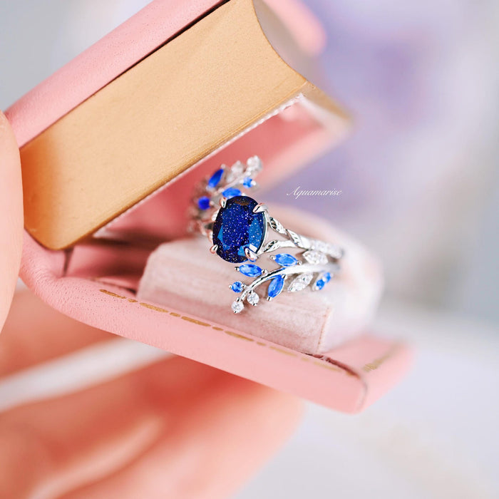 Starry Night & Trees Couples Ring Set by Aquamarise featuring a silver band with a sparkling deep blue galaxy sandstone center stone, accented with delicate blue and clear gemstones in a nature-inspired design.