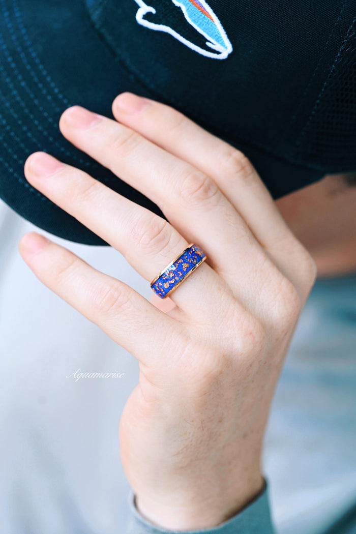 Starry Night Van Gogh Fire Opal & Rose Gold Leaf Couples Ring Set featuring a wide band of deep blue fire opal with scattered rose gold leaf accents, styled on a hand wearing a black cap, crafted by Aquamarise in Matching Couples' Rings and October Birthstone collections.