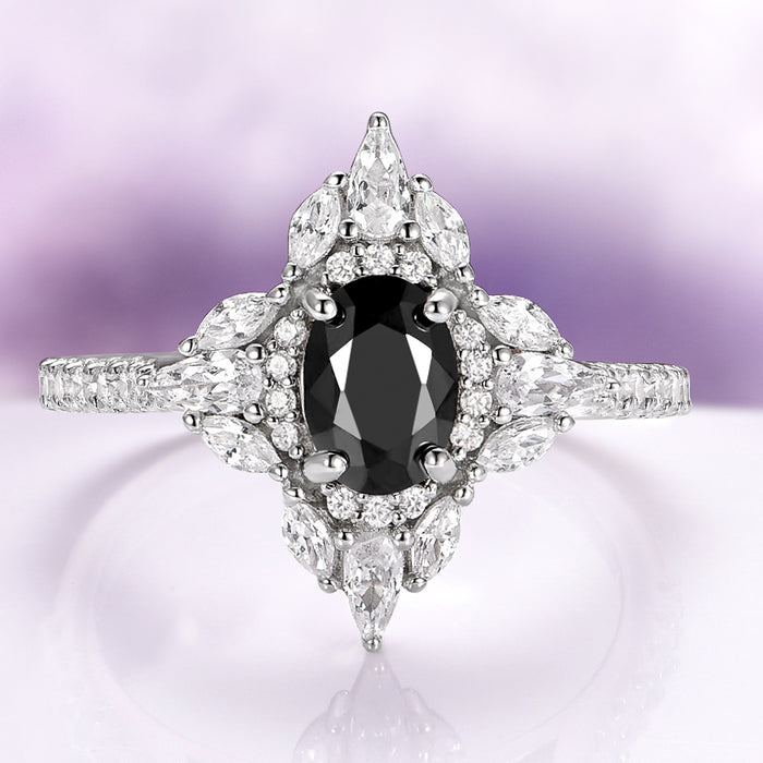 Stella Black Moissanite Engagement Ring in 14K White Gold by Aquamarise Gold featuring an oval black moissanite center with marquise and round white accents in a vintage-inspired design.