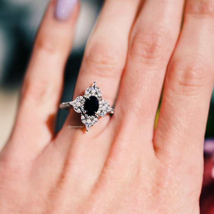 Stella Black Moissanite Engagement Ring in 14K White Gold by Aquamarise Gold featuring a bold oval black moissanite surrounded by pear and round white accents on an elegant polished band.