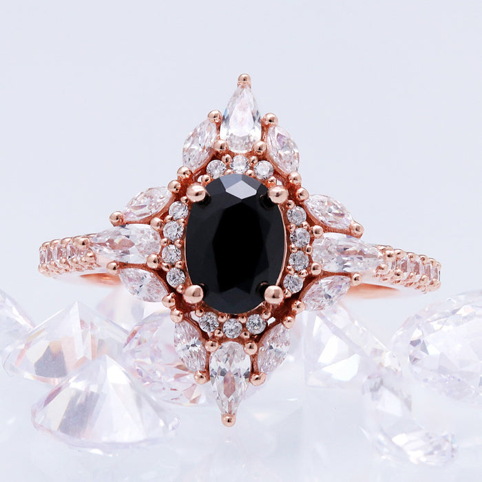 Stella black onyx ring in 14K rose gold vermeil shown beside clear crystals, showing the pave band and marquise halo