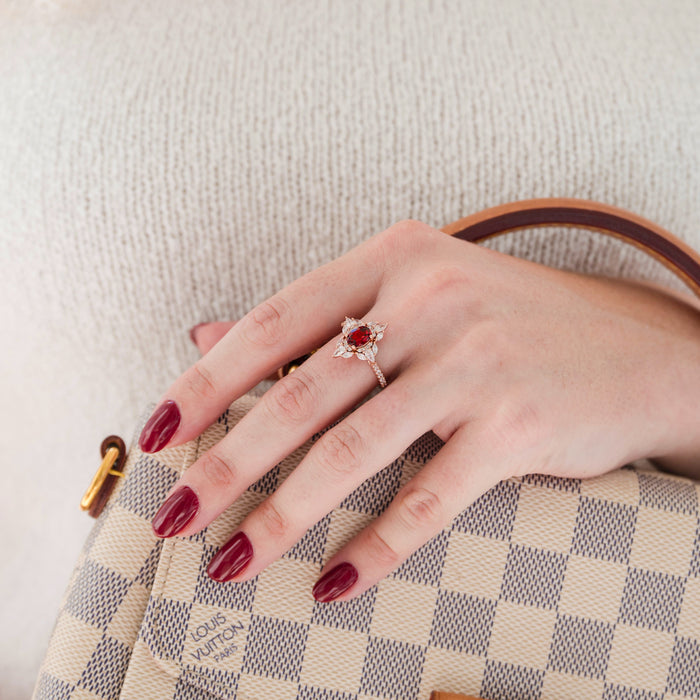 Stella Natural Red Garnet Ring- 14K Rose Gold Vermeil by Aquamarise featuring a vintage-inspired garnet center with pavé accents, styled on a hand with burgundy nails holding a designer handbag.