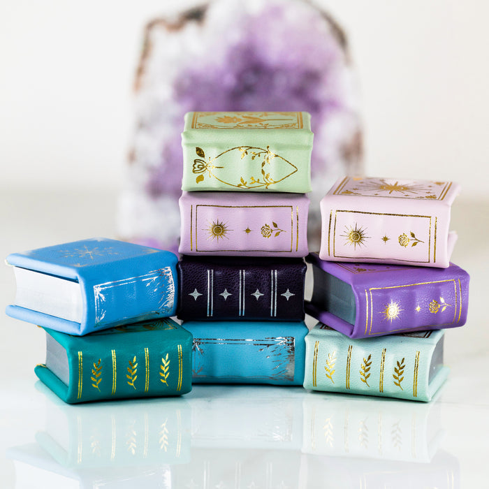 Summer Court Handmade Leather Book Ring Box- Ocean Tide Teal Edition (Small) displayed with colorful handmade book ring boxes by Aquamarise, perfect for meaningful jewelry gifts.