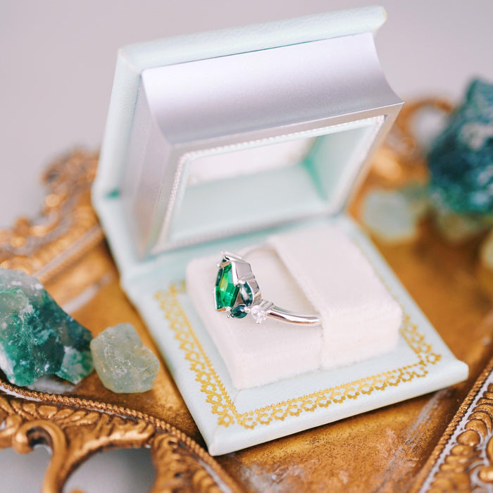Summer Court Handmade Leather Book Ring Box- Seaglass Glow Edition (Small) showing an open pale sea-green box with a silver ring featuring a green gemstone inside, styled with crystals and vintage gold tray.