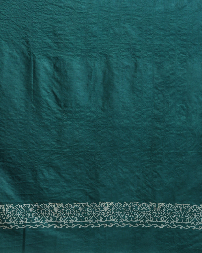 Teal green katan silk unstitched suit set with contrasting pink and white floral hand block print and a rectangular geometric frame bordering the dupatta.