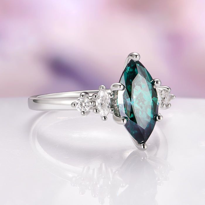 Teal Moissanite Marquise Engagement Ring in 14K White Gold by Aquamarise Gold, showcasing a luminous marquise teal moissanite center stone accented with sparkling colorless moissanites on a polished white gold band, part of non-traditional and fantasy-inspired engagement rings collections.