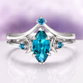 Teal Sapphire Crescent Moon Ring Set in 14K White Gold featuring a marquise-cut teal sapphire center flanked by crescent moon and small round teal sapphires, crafted by Aquamarise Gold from nature-inspired and fantasy engagement collections.