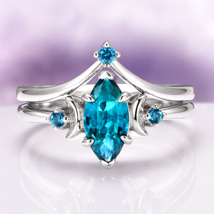 Teal Sapphire Crescent Moon Ring Set in 14K White Gold featuring a marquise-cut teal sapphire center flanked by crescent moon and small round teal sapphires, crafted by Aquamarise Gold from nature-inspired and fantasy engagement collections.