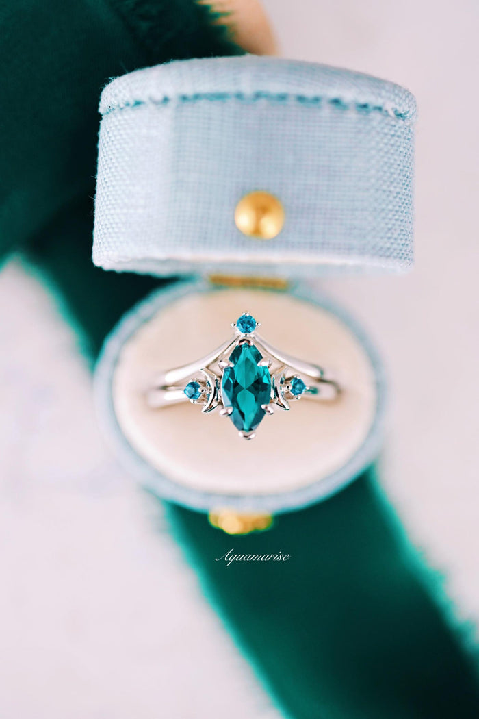 Teal Sapphire Crescent Moon Ring Set in 14K White Gold featuring a marquise-cut teal sapphire center flanked by two smaller round teal sapphires in a delicate white gold setting, crafted by Aquamarise Gold.