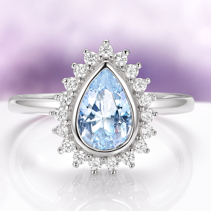 Teardrop Bezel Aquamarine Ring in Sterling Silver by Aquamarise, featuring a sparkling teardrop aquamarine surrounded by cubic zirconia in a vintage-inspired sterling silver setting.