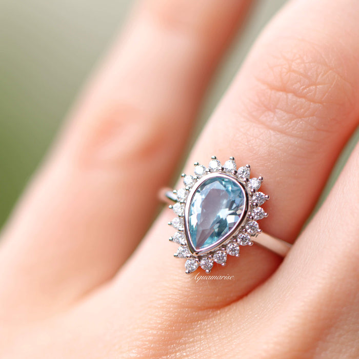 Teardrop Bezel Aquamarine Ring in Sterling Silver by Aquamarise, featuring a lab-created aquamarine surrounded by sparkling cubic zirconia in a vintage-inspired sterling silver setting.