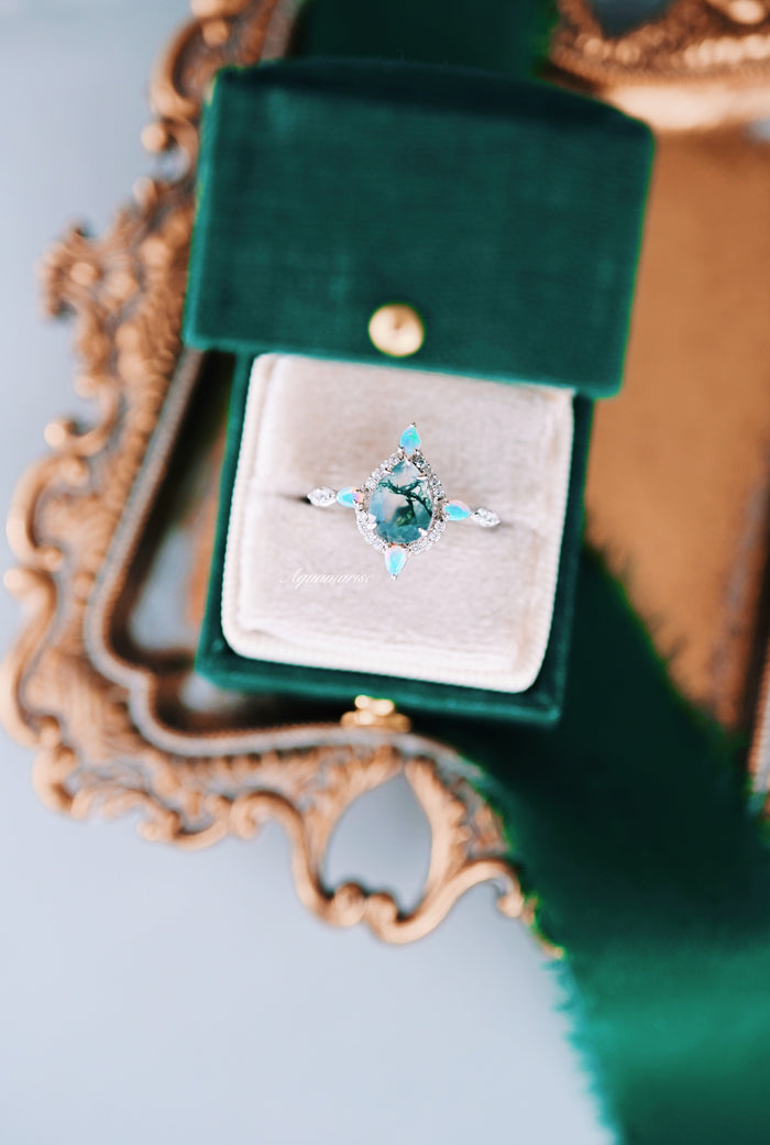 Green Moss Agate & Fire Opal Engagement Ring- 14K White Gold featuring a teardrop moss agate center stone with natural inclusions, accented by delicate fire opal marquise gems and surrounded by sparkling diamonds, presented in a green velvet box by Aquamarise Gold.