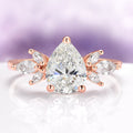 Teardrop White Sapphire Ring in 14K Rose Gold Vermeil by Aquamarise, featuring a 2-carat pear-cut lab-grown white sapphire center with marquise-cut simulated diamonds arranged in a floral design on a rose gold vermeil band, part of Rose Gold Vermeil Rings, September Birthstone Jewelry, and Engagement Rings for Women collections.