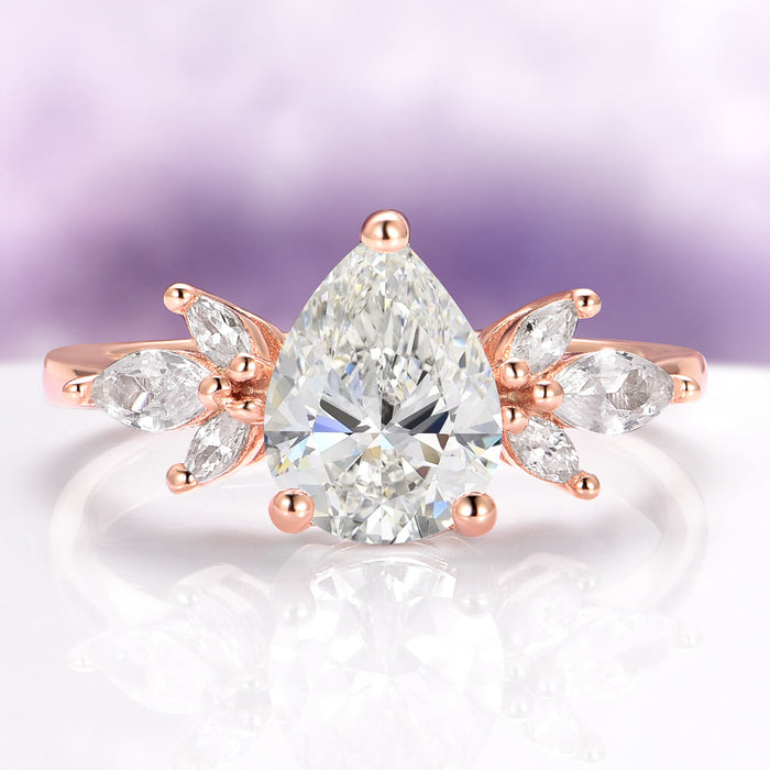 Teardrop White Sapphire Ring in 14K Rose Gold Vermeil by Aquamarise, featuring a 2-carat pear-cut lab-grown white sapphire center with marquise-cut simulated diamonds arranged in a floral design on a rose gold vermeil band, part of Rose Gold Vermeil Rings, September Birthstone Jewelry, and Engagement Rings for Women collections.