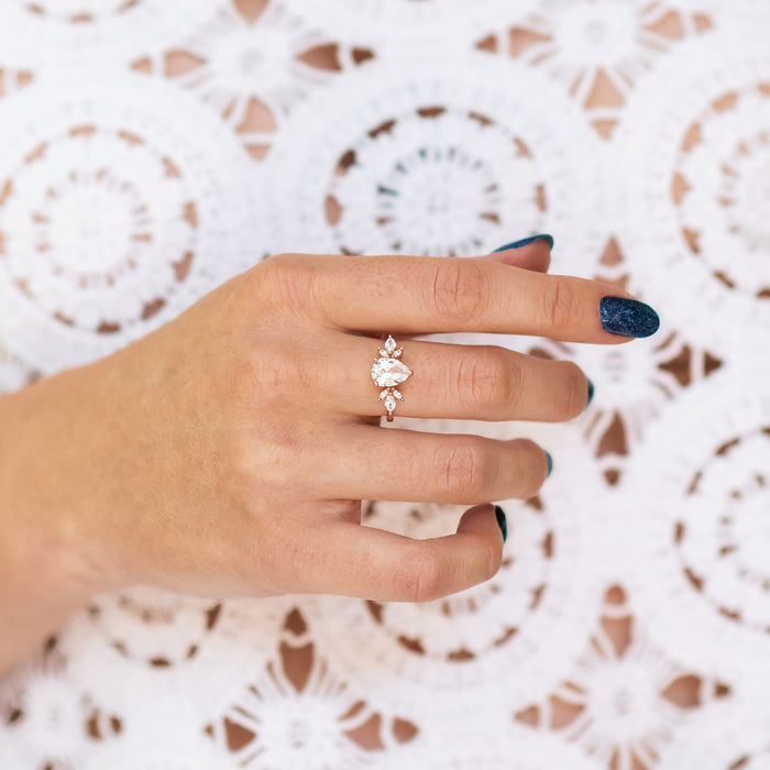 Teardrop White Sapphire Ring in 14K Rose Gold Vermeil by Aquamarise, featuring a 2-carat pear-shaped lab-grown white sapphire with marquise-cut simulated diamonds in a floral arrangement on a delicate rose gold vermeil band, part of Rose Gold Vermeil Rings, September Birthstone Jewelry, and Engagement Rings for Women collections.