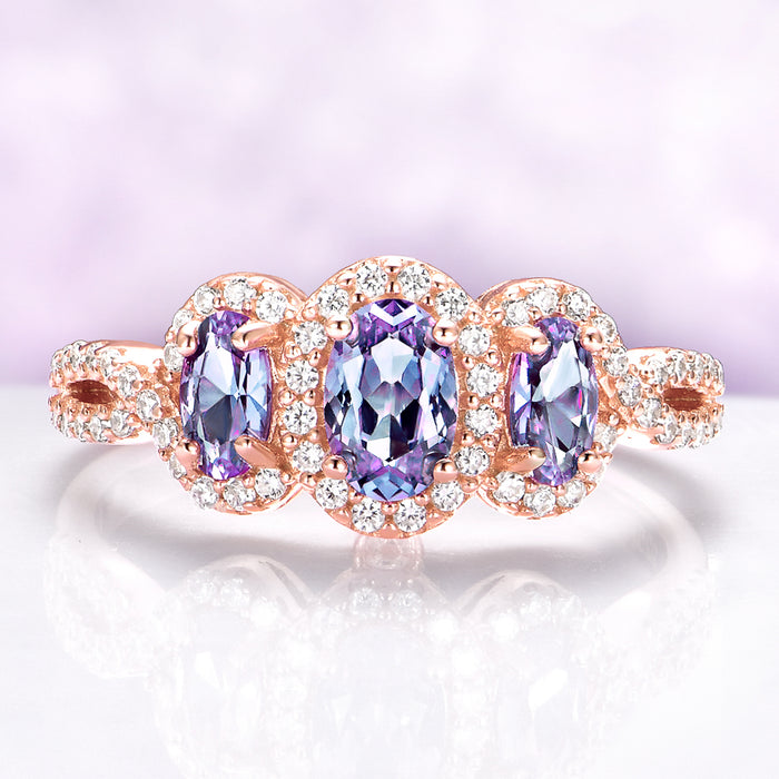 Rose gold ring with purple gemstones on a light purple background