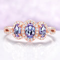 Rose gold ring with purple gemstones on a light purple background