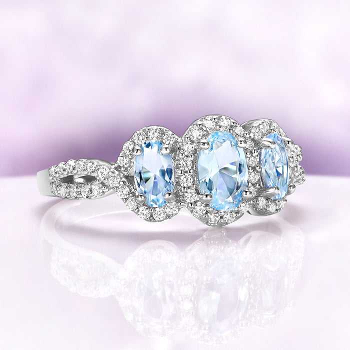 Three Stone Halo Vintage Aquamarine Engagement Ring in Sterling Silver by Aquamarise, featuring three oval aquamarine stones with pavé diamond halos on a twisted split-shank band.