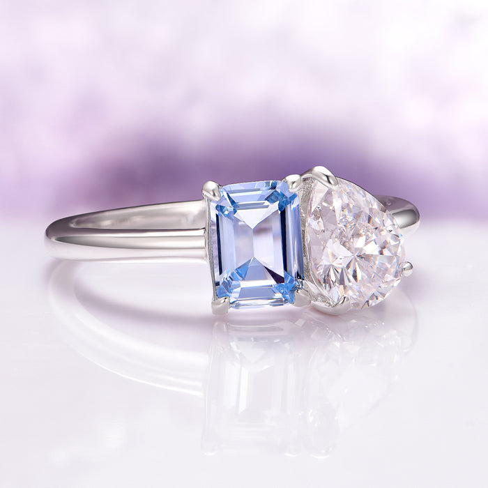 Toi Et Moi Lab-Grown Diamond and Aquamarine Ring- 14K White Gold (IGI Certified) by Aquamarise Gold features a sleek white gold band with a pear-shaped lab-grown diamond and an emerald-cut aquamarine, a unique symbol of love and unity.