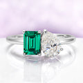 Toi Et Moi Emerald & Moissanite Two Stone Engagement Ring in 14K White Gold by Aquamarise Gold, featuring a lab-grown emerald-cut emerald and pear-shaped D/VVS1 moissanite in a unique design.