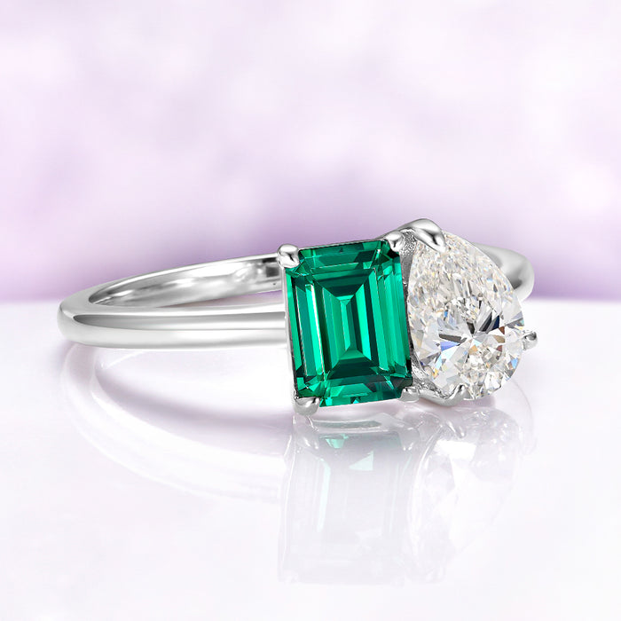Toi Et Moi Emerald & Moissanite Two Stone Engagement Ring in 14K White Gold by Aquamarise Gold, featuring a lab-grown emerald-cut emerald and pear-shaped moissanite in a modern design.