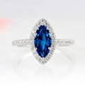 Valeria Marquise Halo Blue Sapphire Ring- Sterling Silver by Aquamarise, featuring a marquise royal blue sapphire surrounded by a halo of sparkling stones on a sterling silver band.
