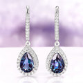 Vera Teardrop Lab-Grown Alexandrite Drop Earrings in Sterling Silver by Aquamarise, featuring deep purple teardrop gemstones framed by sparkling sterling silver with diamond accents.