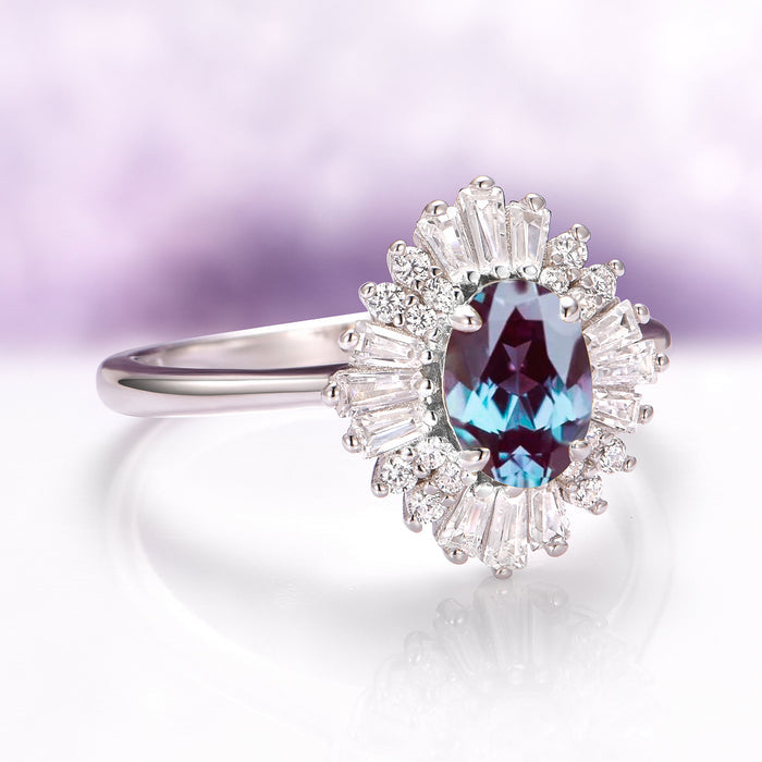 Victoria Art Deco Alexandrite Engagement Ring in 14K White Gold by Aquamarise Gold featuring an oval alexandrite center with a halo of tapered baguette and round moissanite accents.