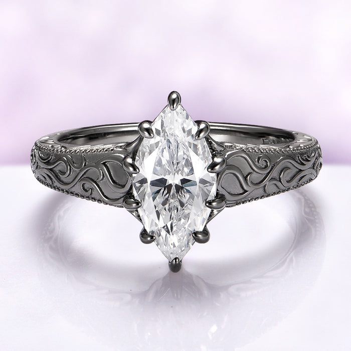 Victorian Gothic Moissanite Filigree Engagement Ring in Black Ruthenium featuring a marquise cut stone on a black ruthenium-finished sterling silver band with intricate Victorian scrollwork by Aquamarise Gold.