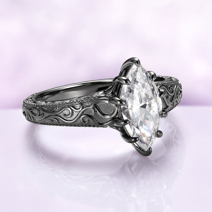 Victorian Gothic Moissanite Filigree Engagement Ring in Black Ruthenium by Aquamarise Gold featuring a marquise moissanite center and detailed Victorian scrollwork on a black ruthenium silver band.