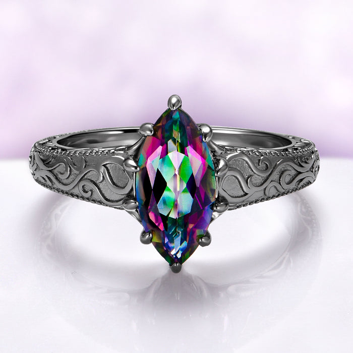 Victorian Gothic Mystic Topaz Filigree Engagement Ring in Black Ruthenium by Aquamarise featuring a marquise mystic topaz and detailed Victorian scrollwork on a black ruthenium silver band.