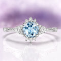 Vintage Round Cut Aquamarine Ring in Sterling Silver by Aquamarise featuring a delicate round aquamarine center with intricate vintage-inspired diamond accents on a detailed silver band.