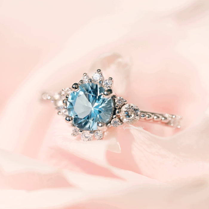 Vintage Round Cut Aquamarine Ring in Sterling Silver by Aquamarise featuring a radiant round aquamarine center with sparkling diamond accents on a delicate detailed silver band.